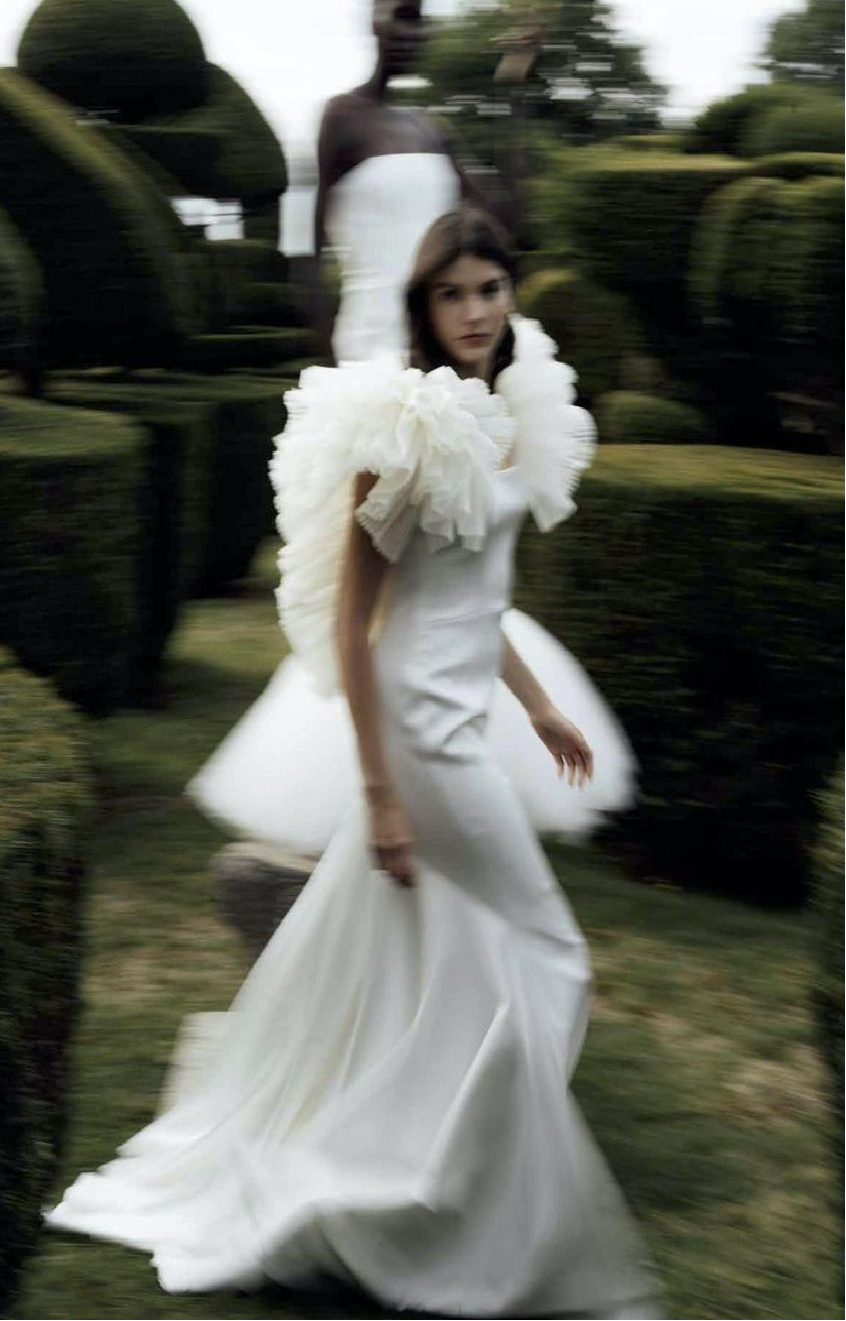 Noiva em vestido esculpido caminhando em jardim